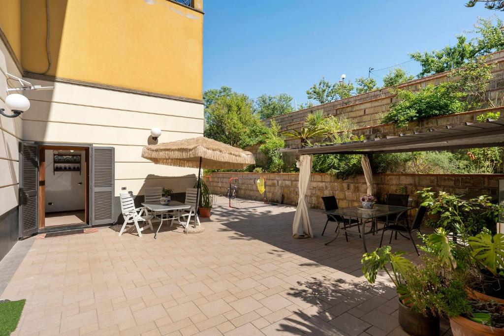 a patio with a table and an umbrella at B&B Pozzuoli - Suite Ermosa in Pozzuoli