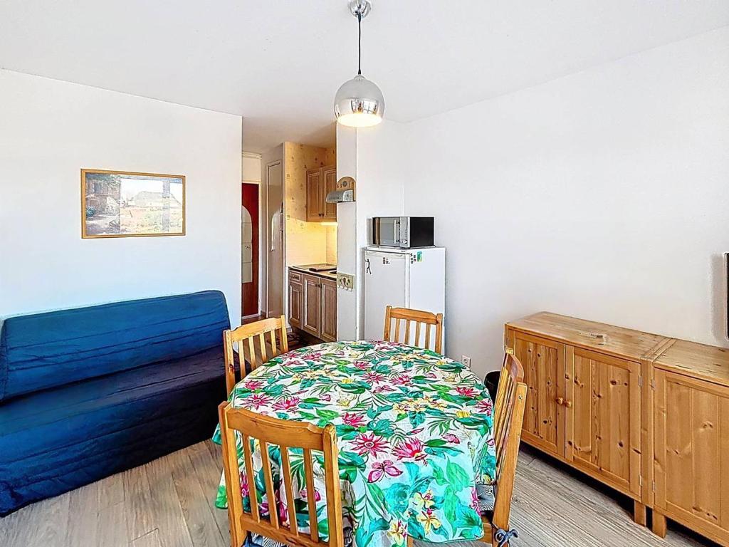 a kitchen with a table and a refrigerator at Charmant Studio Cabine 4 Pers, Balcons, Parking Privé, à 300m de la Plage de Merville-Franceville - FR-1-465-37 in Merville-Franceville-Plage