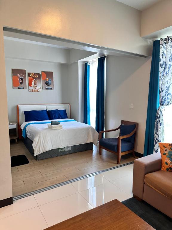 a bedroom with a king sized bed and a couch at C1-7G Executive Studio with pool , 8boulevard Mactan Newtown in Lapu Lapu City