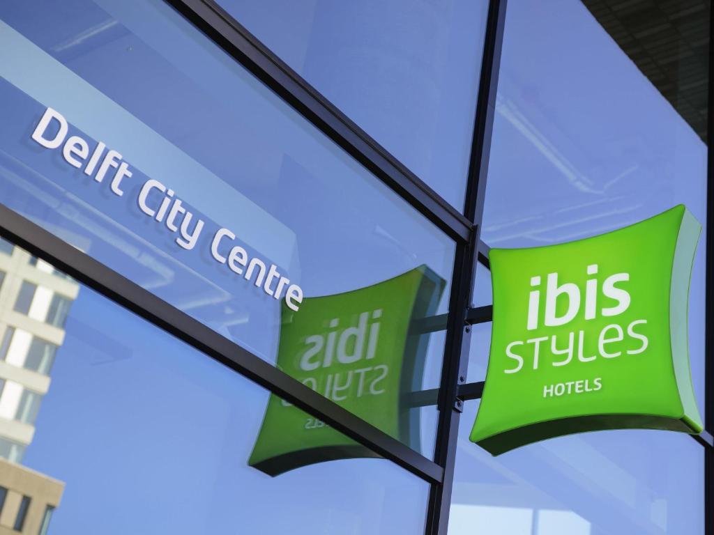 a window with the sign of aitz plus hotels at ibis Styles Delft City Centre in Delft