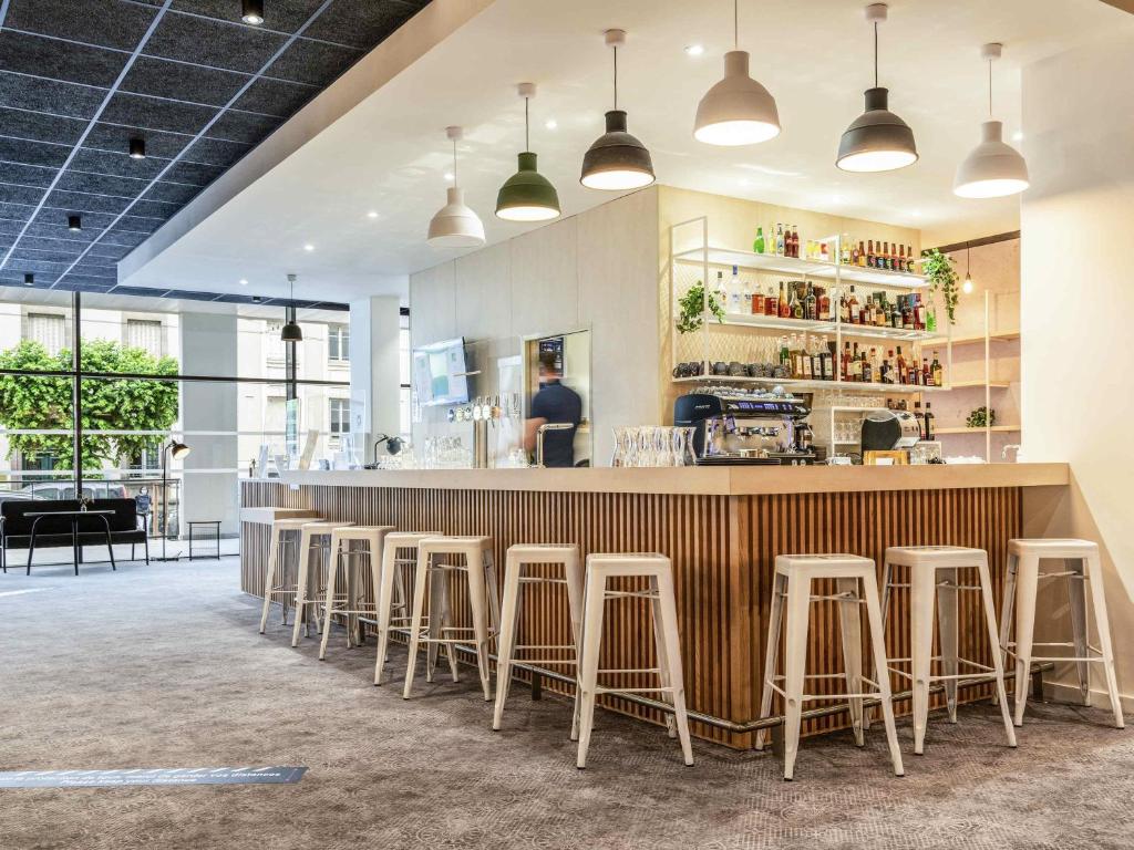 a bar in a restaurant with stools at ibis Styles Limoges Centre in Limoges