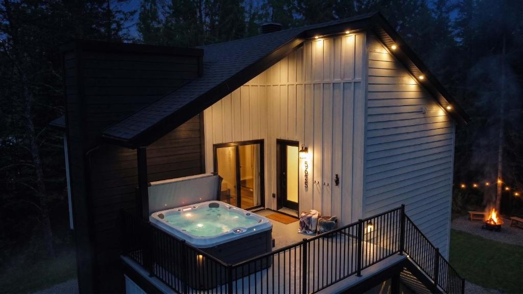 a hot tub on the deck of a house at night at Condo and Spa - Le Saloon Nordik in Saint Come
