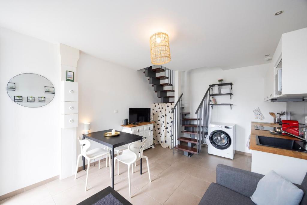 a kitchen and dining room with a table and chairs at L'évasion - duplex in Zillisheim