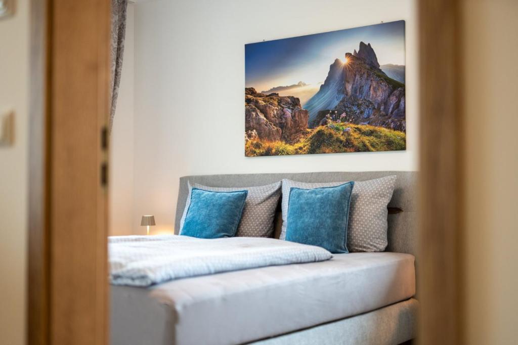a bedroom with a bed with blue pillows at FeWo Iller im Allgäu in Sonthofen