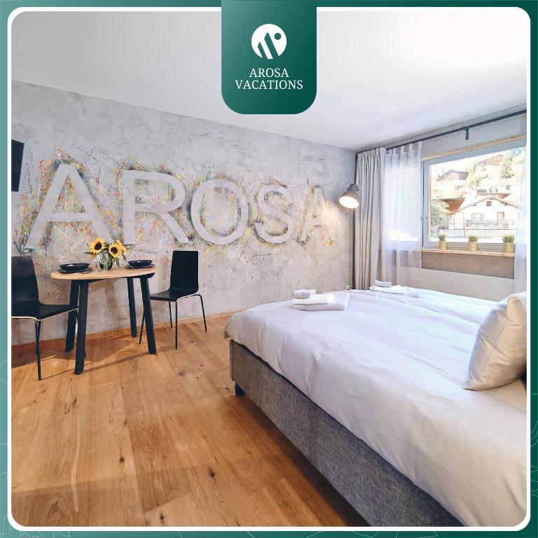 a bedroom with a large bed and a table at Derby 14 by Arosa Vacations, Design-Studio Direkt am Obersee in Arosa
