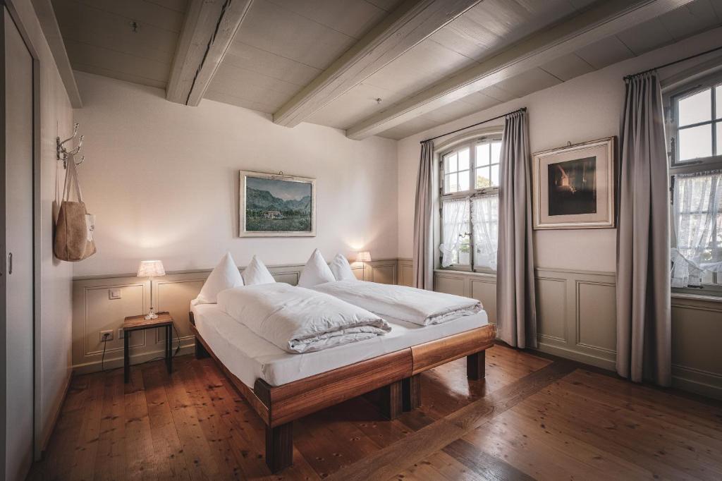 a bedroom with a bed with white sheets on it at Hotel Kreuz in Dürrenroth