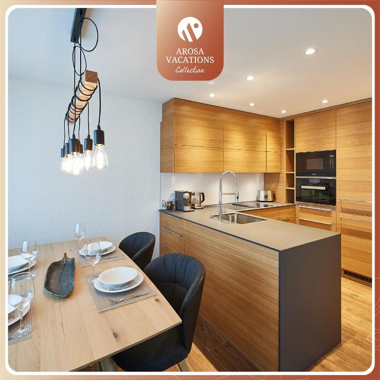 a kitchen with a dining table and a kitchen island at Residence Eden L by Arosa Vacations, Exklusive Apartment im Zentrum in Arosa