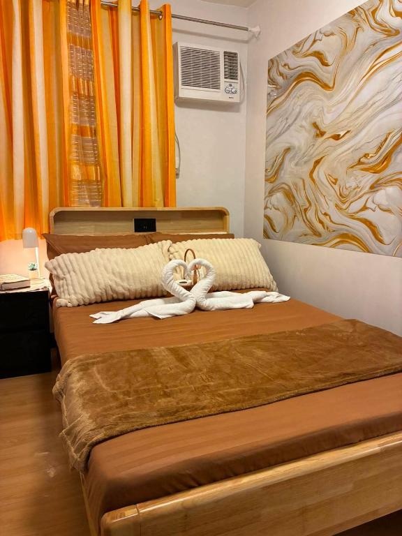 ein Schlafzimmer mit einem Bett, auf dem Handtücher liegen in der Unterkunft Chyns Suite in Marilao