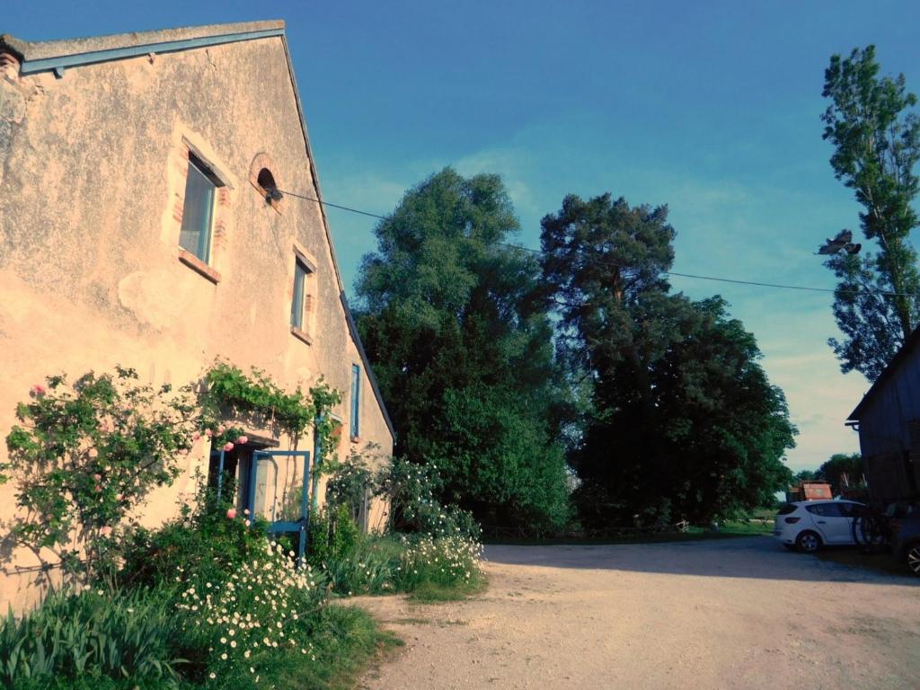 an old building with a car parked next to it at Chambres d'hôtes Ferme de Sardonnet in Allouis
