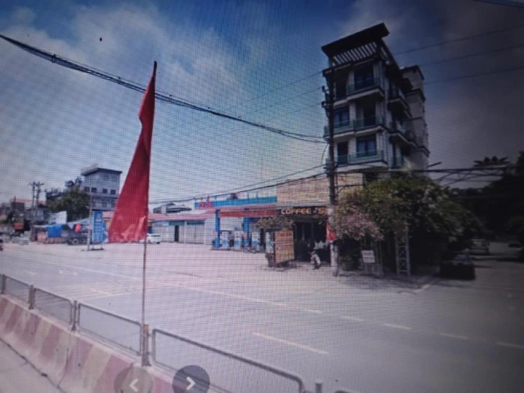 a street with a building and a red flag at PHƯƠNG LƯU Hotel in Văn Lâm