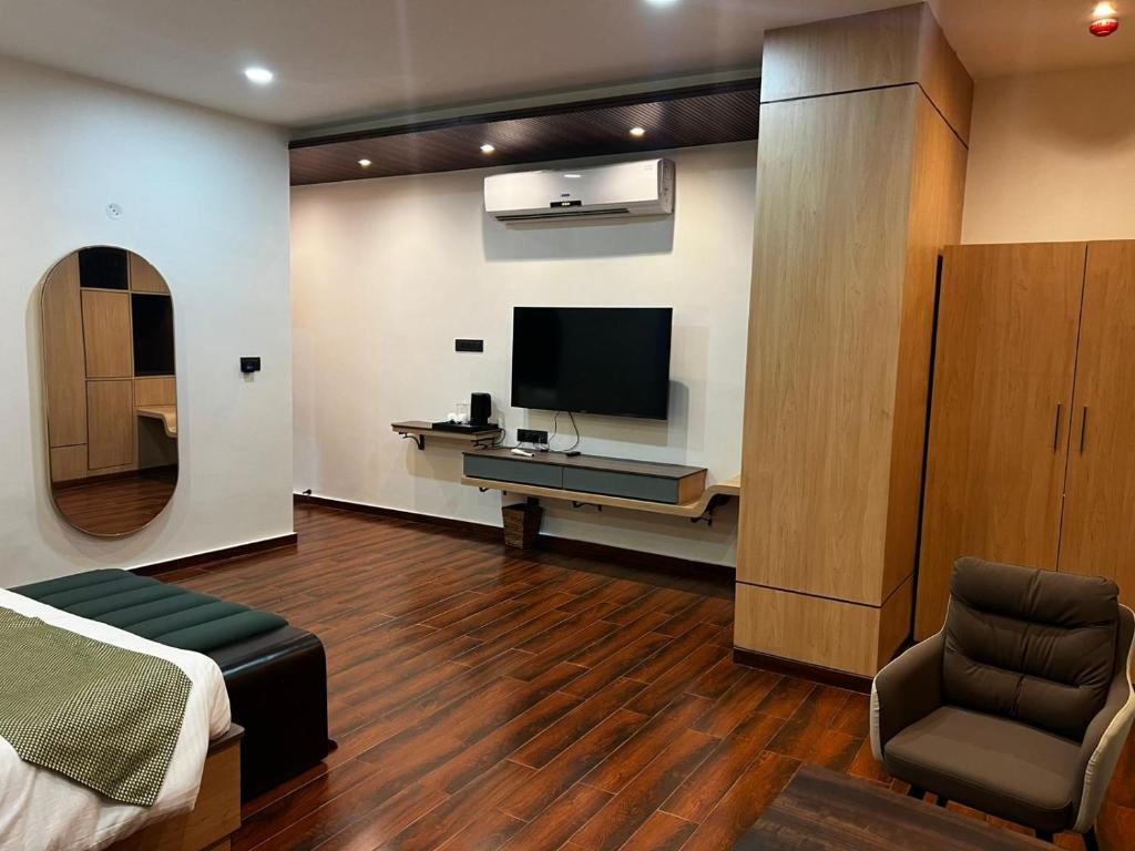 a bedroom with a bed and a tv and a chair at Nandan Inn in Dibrugarh