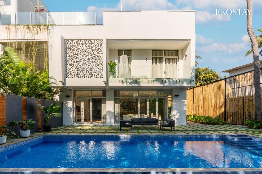 a house with a swimming pool in front of it at EKOSTAY Luxe I Avante Villa in Calangute