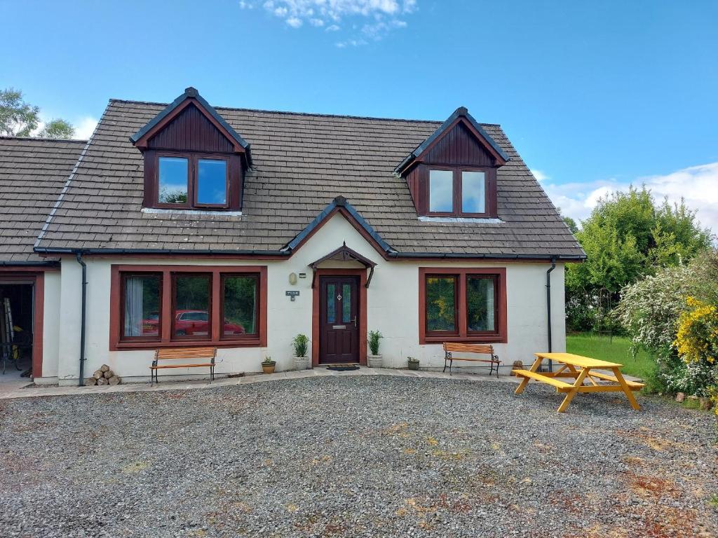 a house with a picnic table in front of it at Tylone in Lochdon