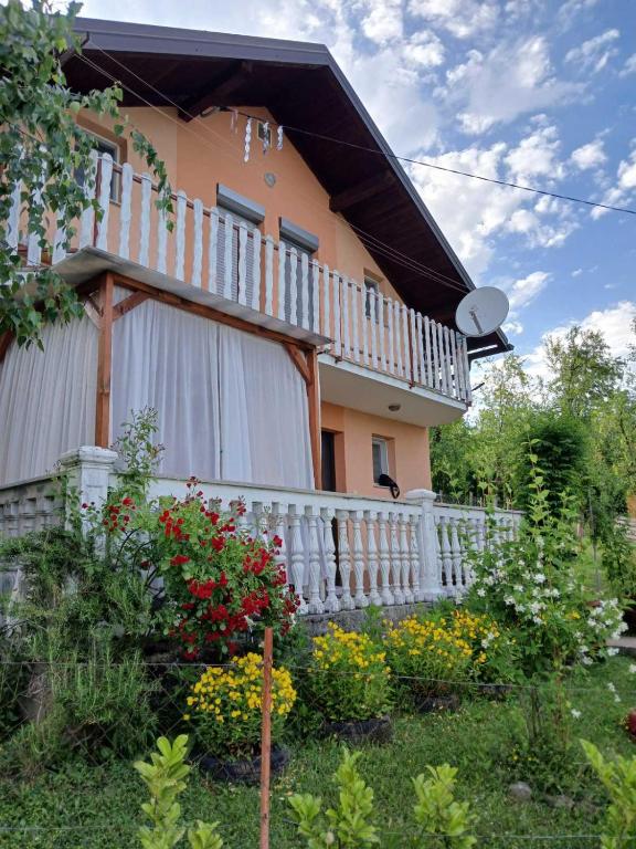 a house with a white fence and some flowers at Vikendica Cokori - private pool and jacuzzi in Banja Luka