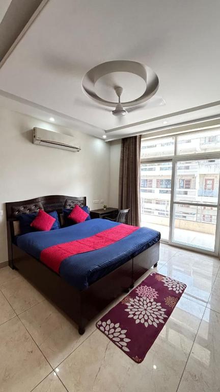 a bedroom with a bed with a blue comforter at Utk 3 in Panchkula