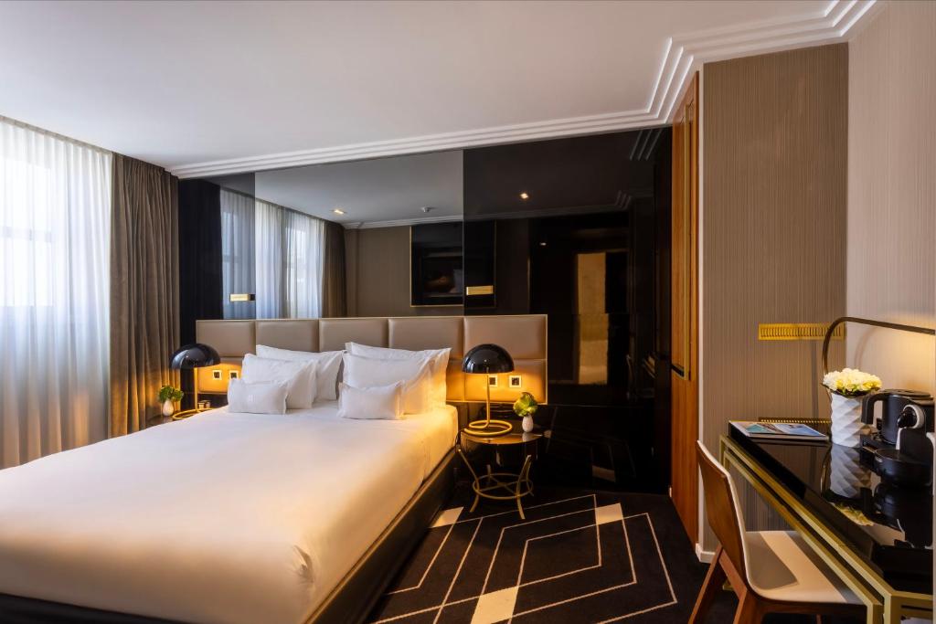 A refined bedroom with a large bed, generous mirrors and an in-room tea or coffee setup.