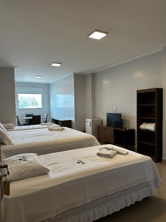 a bedroom with two beds and a television in it at Danny's Hotel in Tailandia