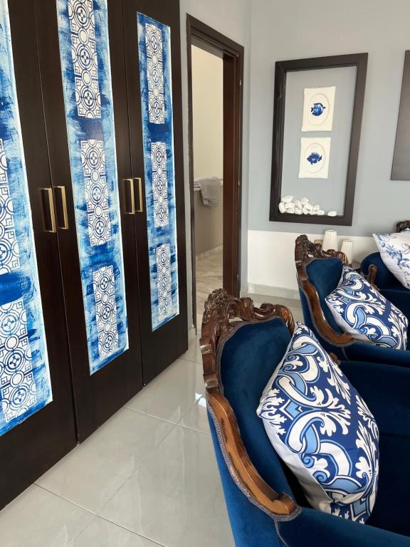 a living room with blue and white pillows on chairs at palazzo PADINI alla costa in Neoi Epivates