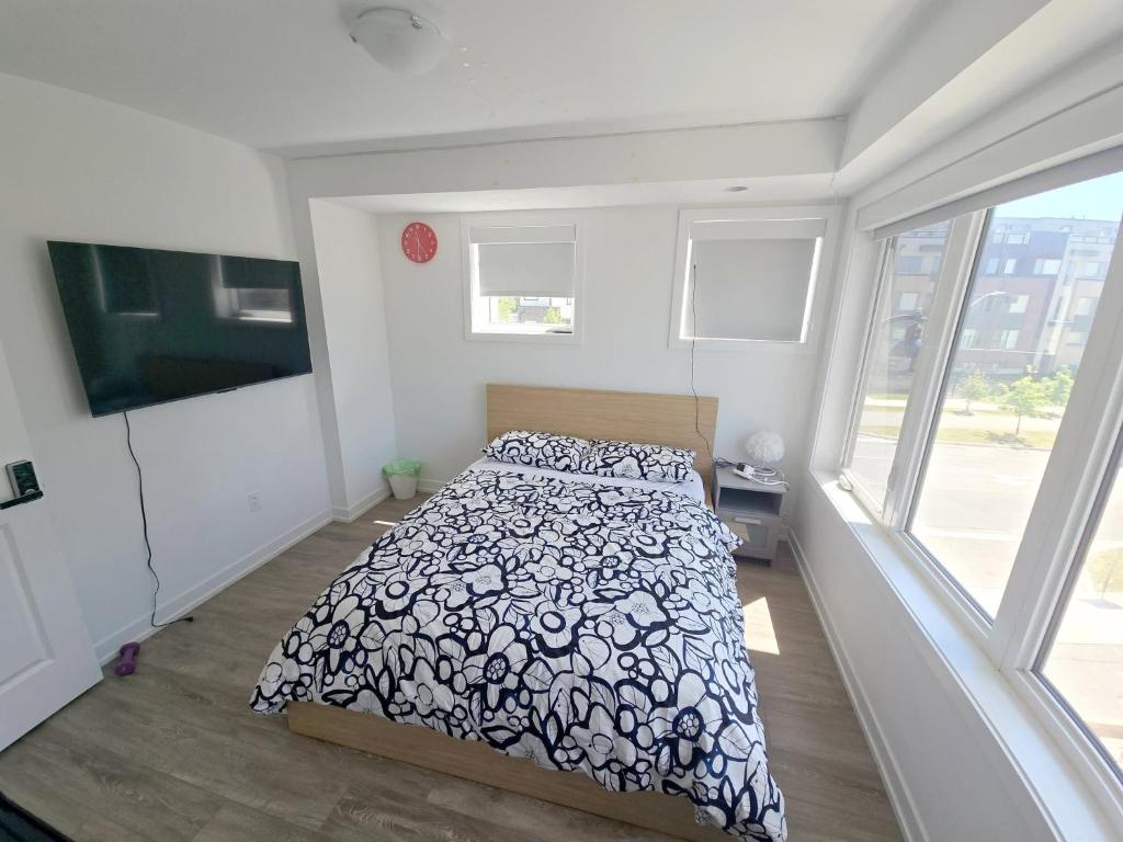 a bedroom with a bed with a black and white comforter at Downsview Park Retreat 1 - Rogers Stadium Getaway in Toronto