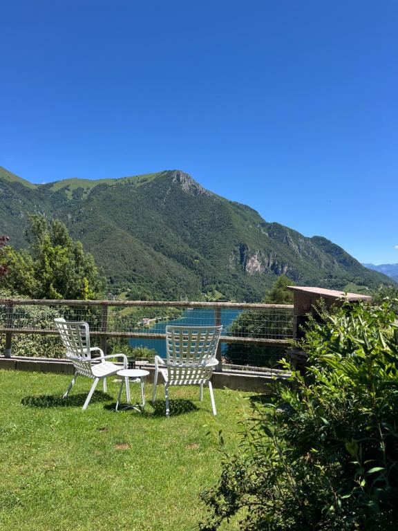 a group of chairs sitting in the grass with mountains at Casa Europa in Ledro