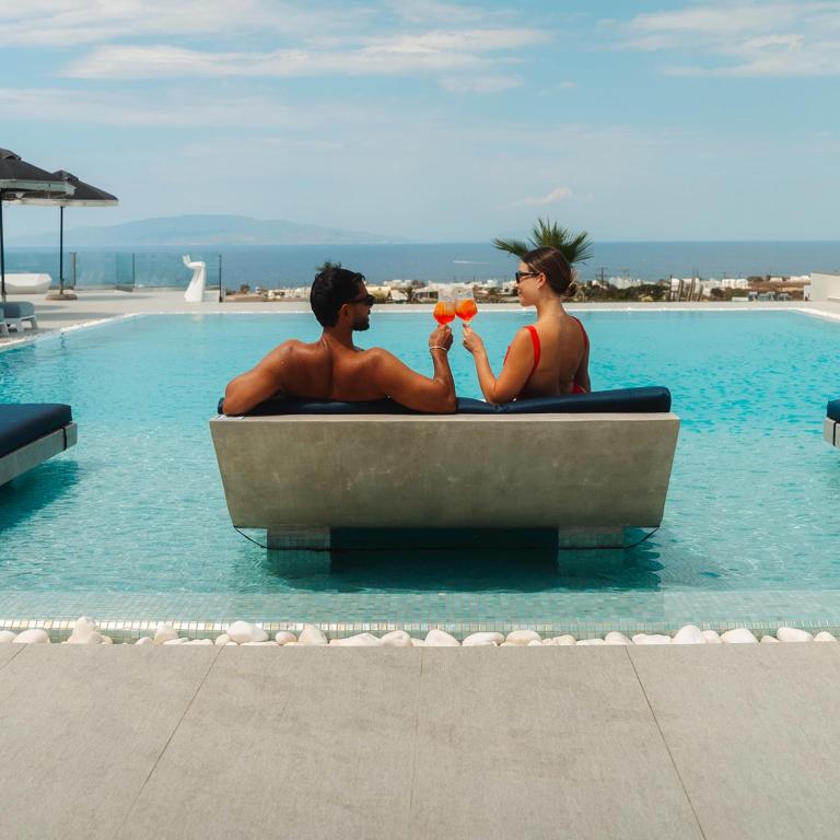 two people sitting in a bath tub in the pool at Myst Boutique Hotel in Oia
