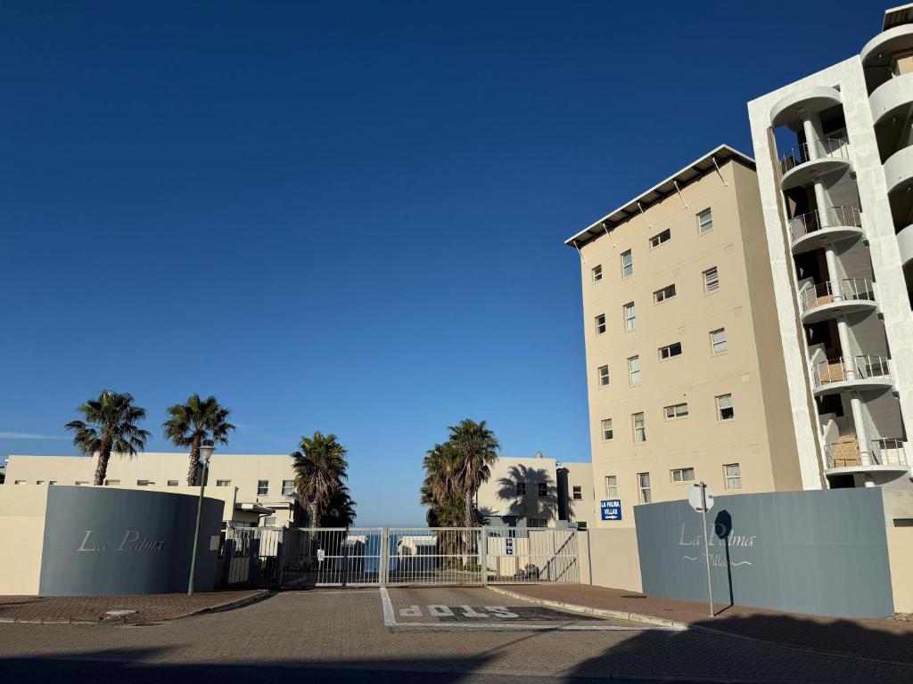 a building with palm trees in front of a building at La Palma villas 6 in Mossel Bay