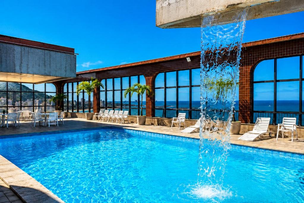 a swimming pool with a water fountain at Flat Pasárgada 404 in Vila Velha