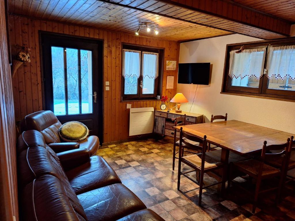 a living room with a leather couch and a table at Appartement proche stations de ski in Abondance