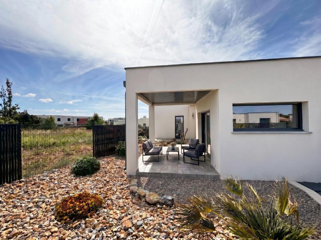 a white house with two chairs and a table at Villa Palmiers 5 min de la Mer, confortable 4 Personnes, parking free, in Sérignan