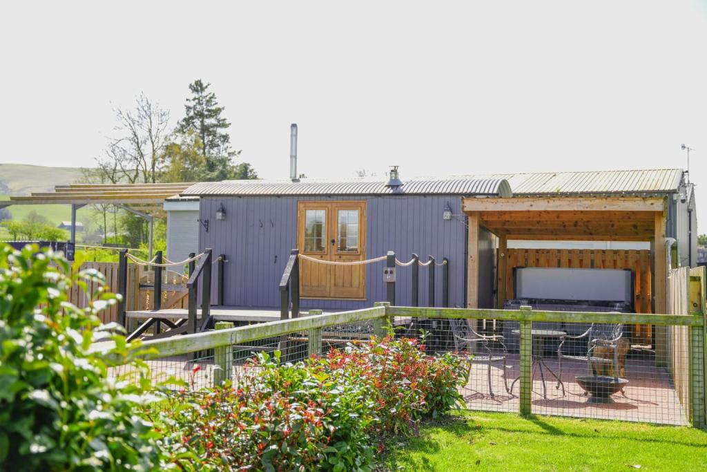 a tiny house with a deck and a backyard at Rose in Rhayader