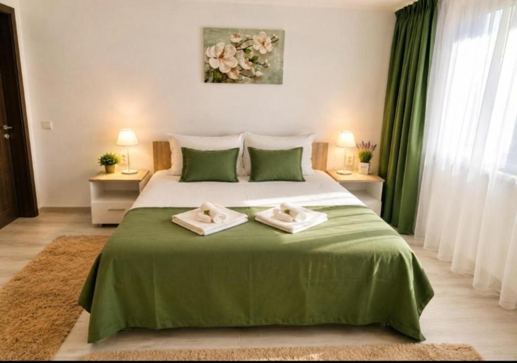 a bedroom with a large bed with two towels on it at CASA ROTARU in 2 Mai