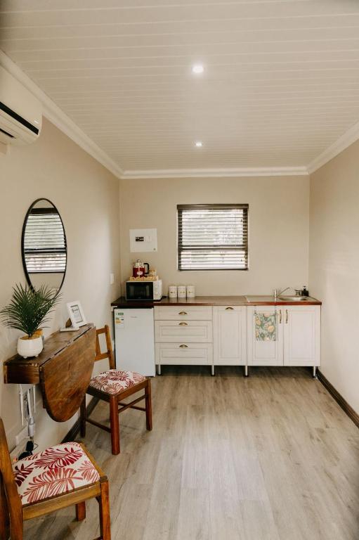 a living room with a table and a mirror at Benedicto Farm in Welkom