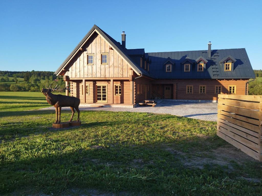 a statue of a deer in front of a house at Roubenka za Horou in Orlické Záhoří 