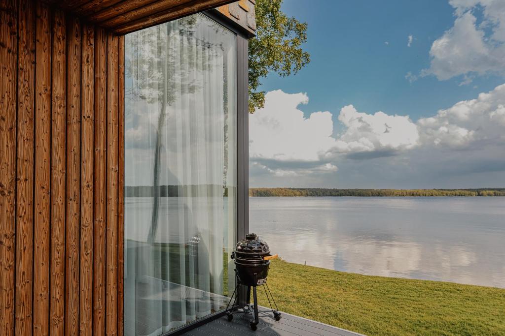 a screened in porch with a view of a lake at Lavyso perlai, 3-4 nameliai in lavysas