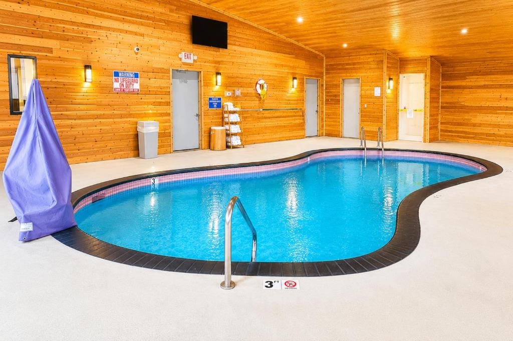 a large swimming pool in a room with wooden walls at Days Inn by Wyndham Hinckley in Hinckley