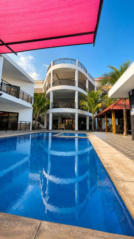 a large building with a swimming pool in front of it at Hotel Portofino in Canoguero