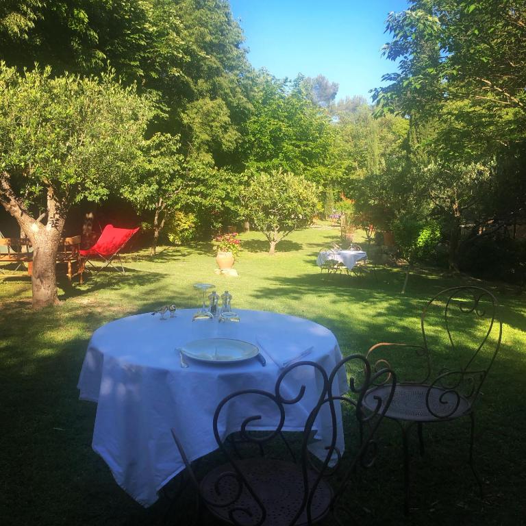 a table with a white table cloth sitting in a yard at B&B Villa Roumanille in Aix-en-Provence