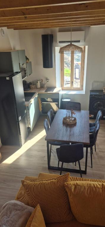 a living room with a table and a kitchen at Duplex Le Trèfle in Charmes-sur-lʼHerbasse