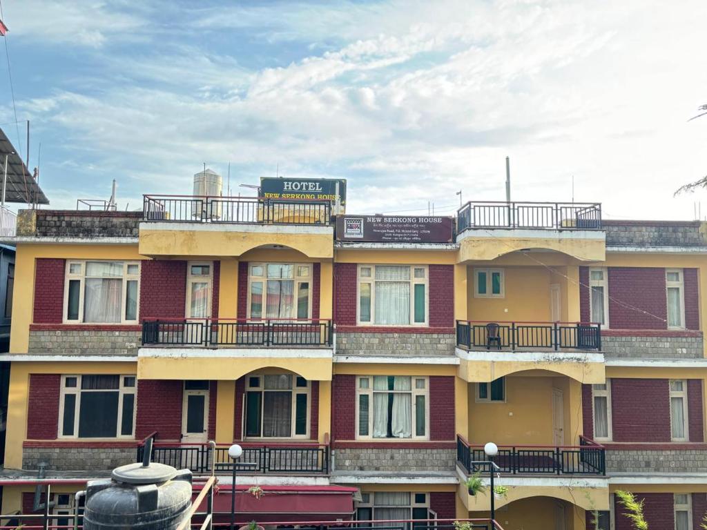 a building with a sign on top of it at Serkong Rabsel House in Dharamshala