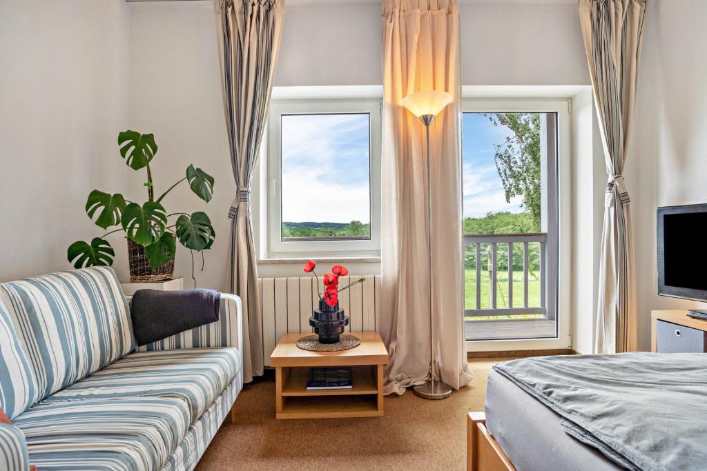a living room with a couch and a television at Mohnrot - Fulgenhaus in Klein Bollhagen