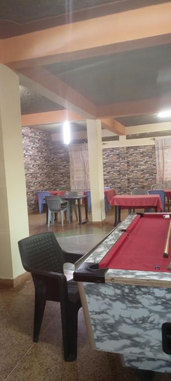 a pool table in a room with tables and chairs at Charonyi Safari Lodge in Gutini