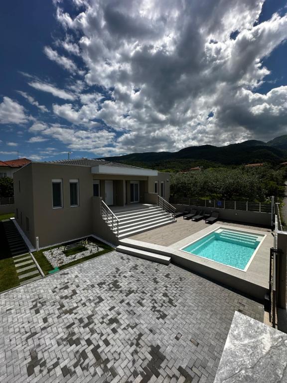 a villa with a swimming pool and a house at MARRONI RETREAT - Pool - Spa - Gym in Skotina