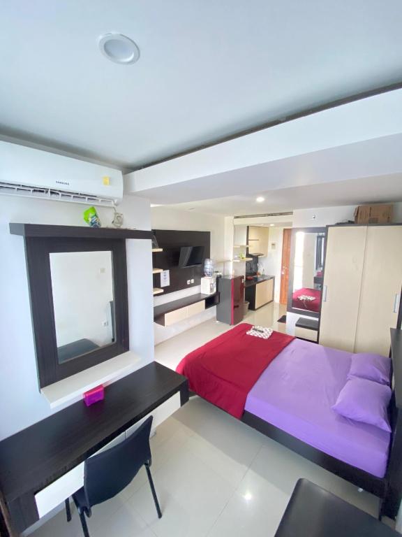 a bedroom with a bed and a desk and a television at Vinsroom Dua at Green Park in Seturan