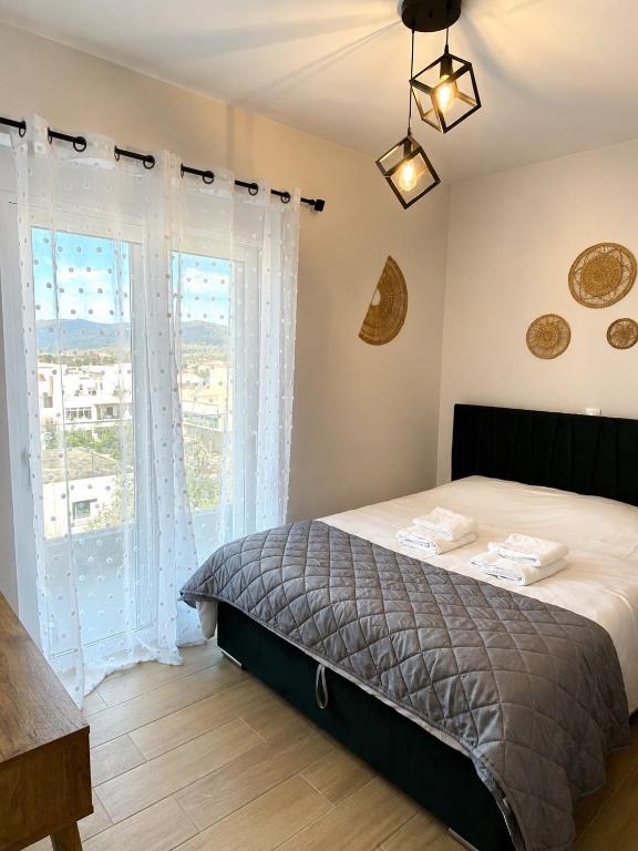 a bedroom with a bed and a large window at Anastasia Karystos in Karistos