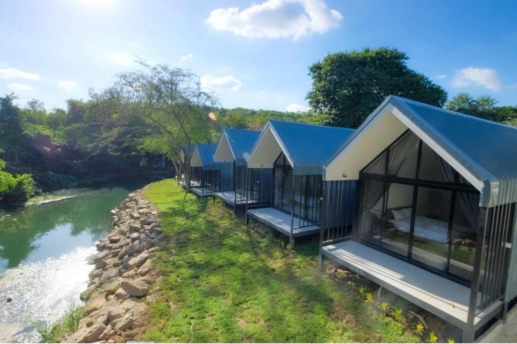a row of cottages next to a river at พฤกษา วัลเลย์ รีสอร์ท in Ban Mak