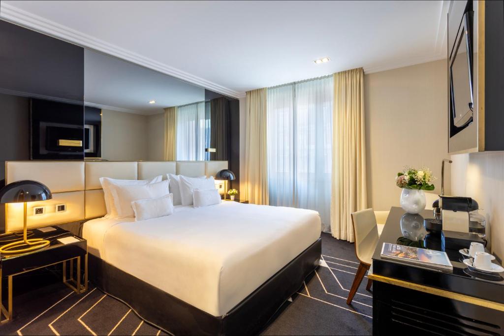 A stylish king room with a large bed, window seating and a compact desk.
