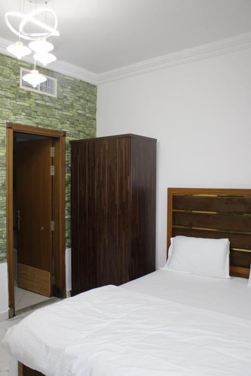 a bedroom with a large bed and a wooden cabinet at Sea View Apartment with Balcony in Ajman 