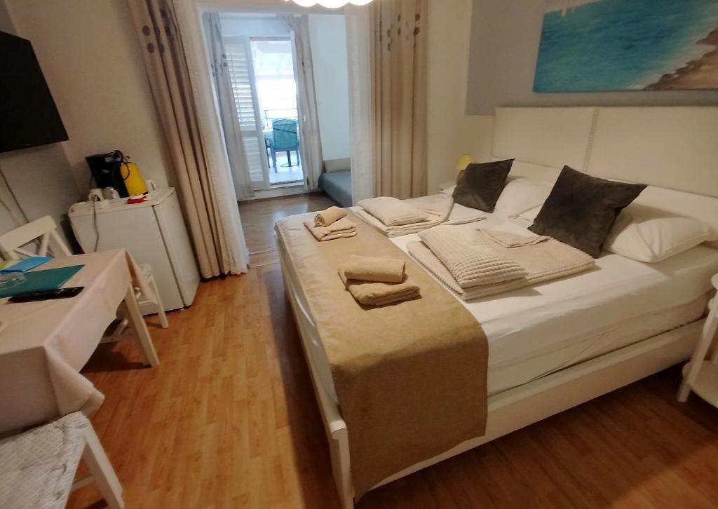 a bedroom with a bed with towels on it at Rooms and apartments PALMA B&B in Medulin
