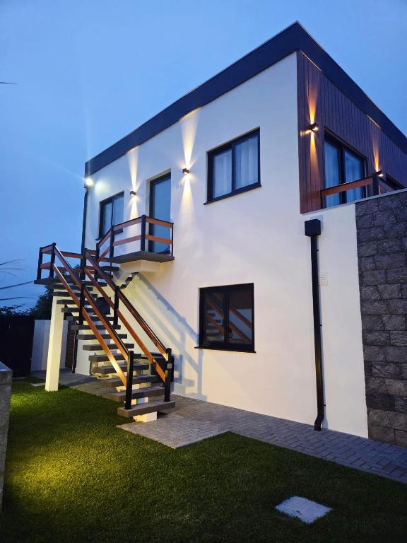 a white house with a staircase in a yard at Francisca Apartment in Lajes