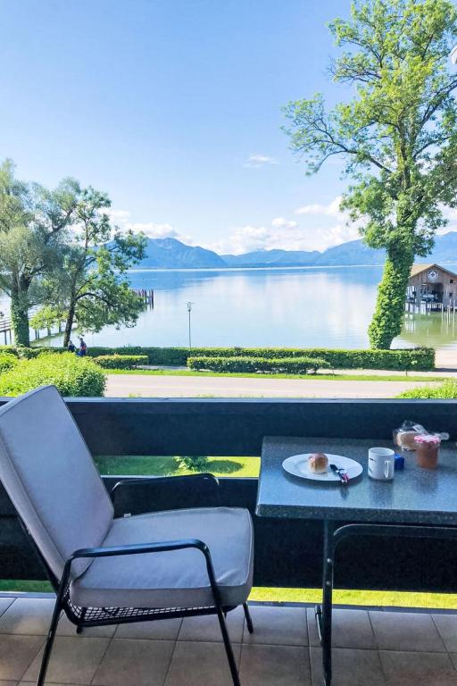 a chair and a table and a view of a lake at Apartment Alpenseeblick by Interhome in Seebruck